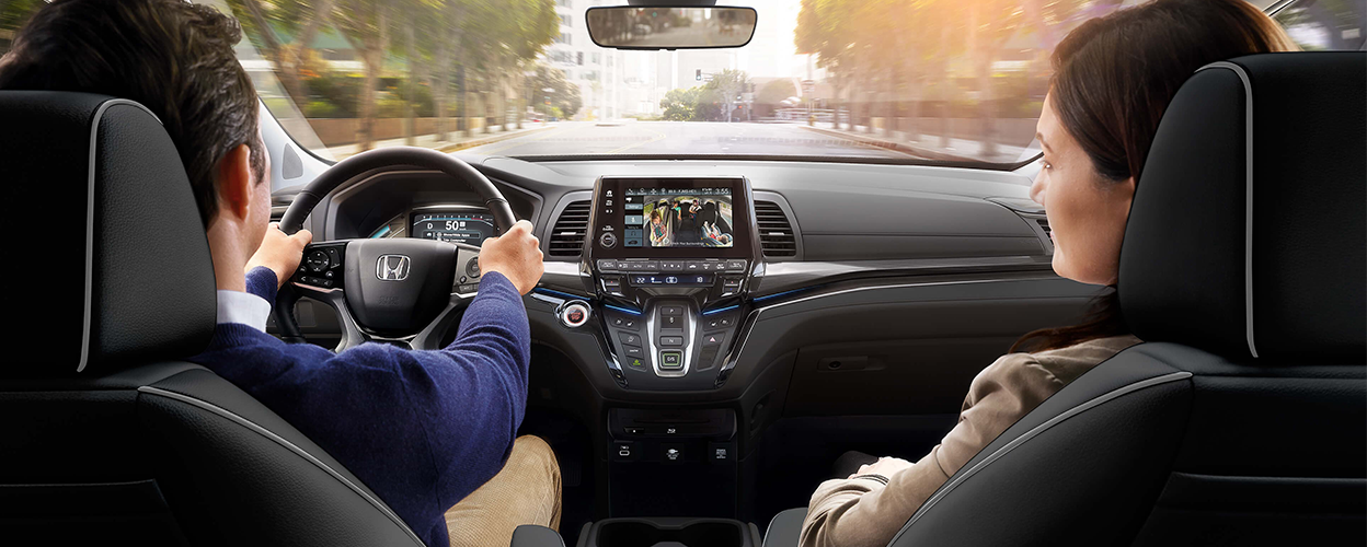 Couple in front seats. Kids on in the back projected on centre console touchscreen.